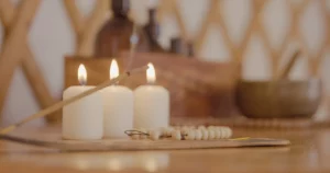 Lit candles, incense, and wooden beads arranged in a peaceful setting at Moka Surf House, capturing the essence of the Yoga & Wellness Package.