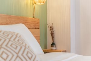 Close-up of the wooden headboard and natural decor details in the First Floor Double Room at Moka Surf House.
