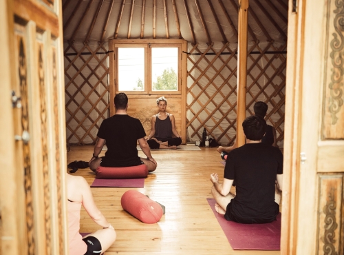 Hatha yoga session inside the yurt with a group of people meditating, Moka Surf House, Ericeira Portugal